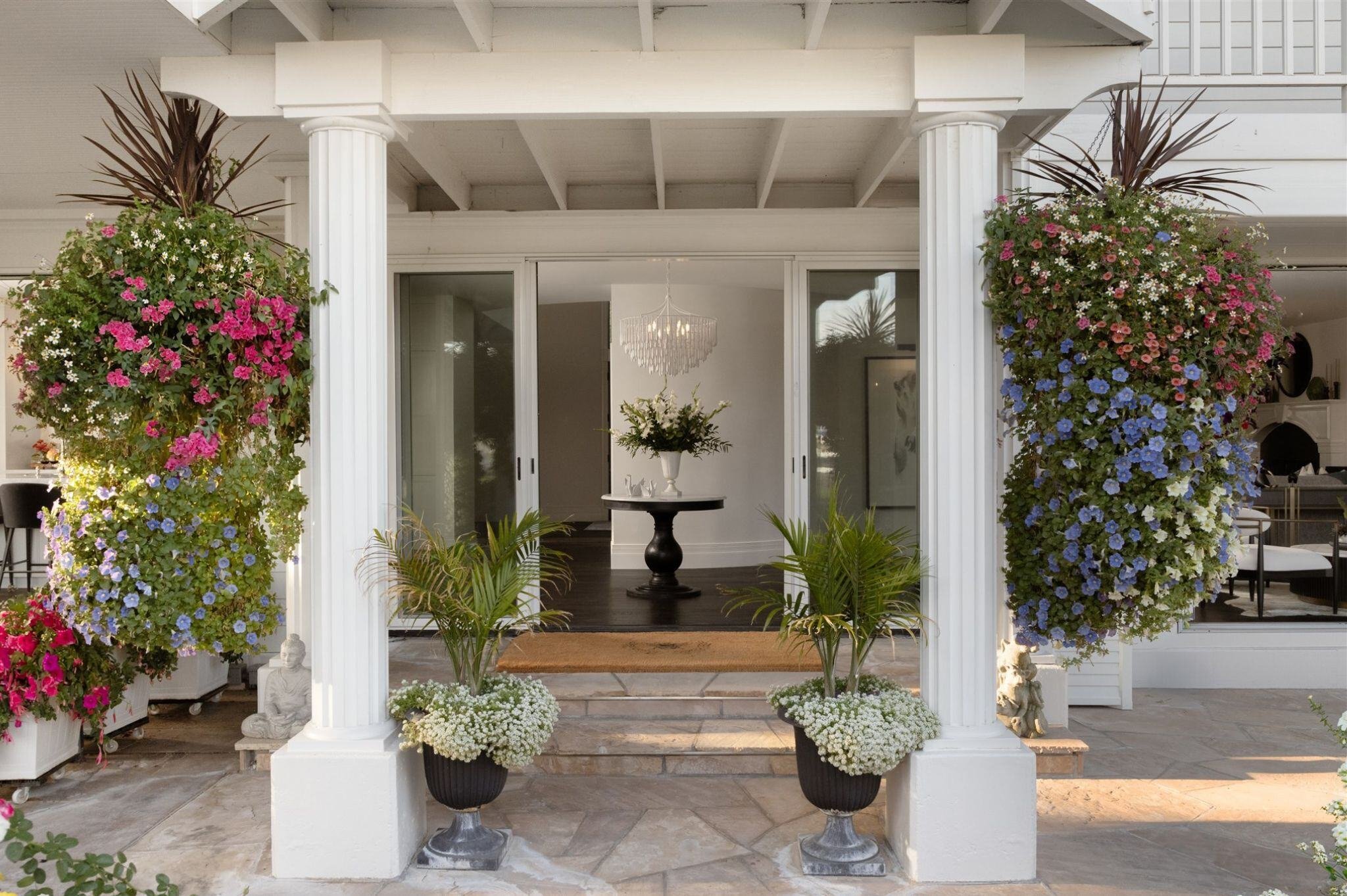 Back patio of a large home in Colorado with large hanging plants and flowers