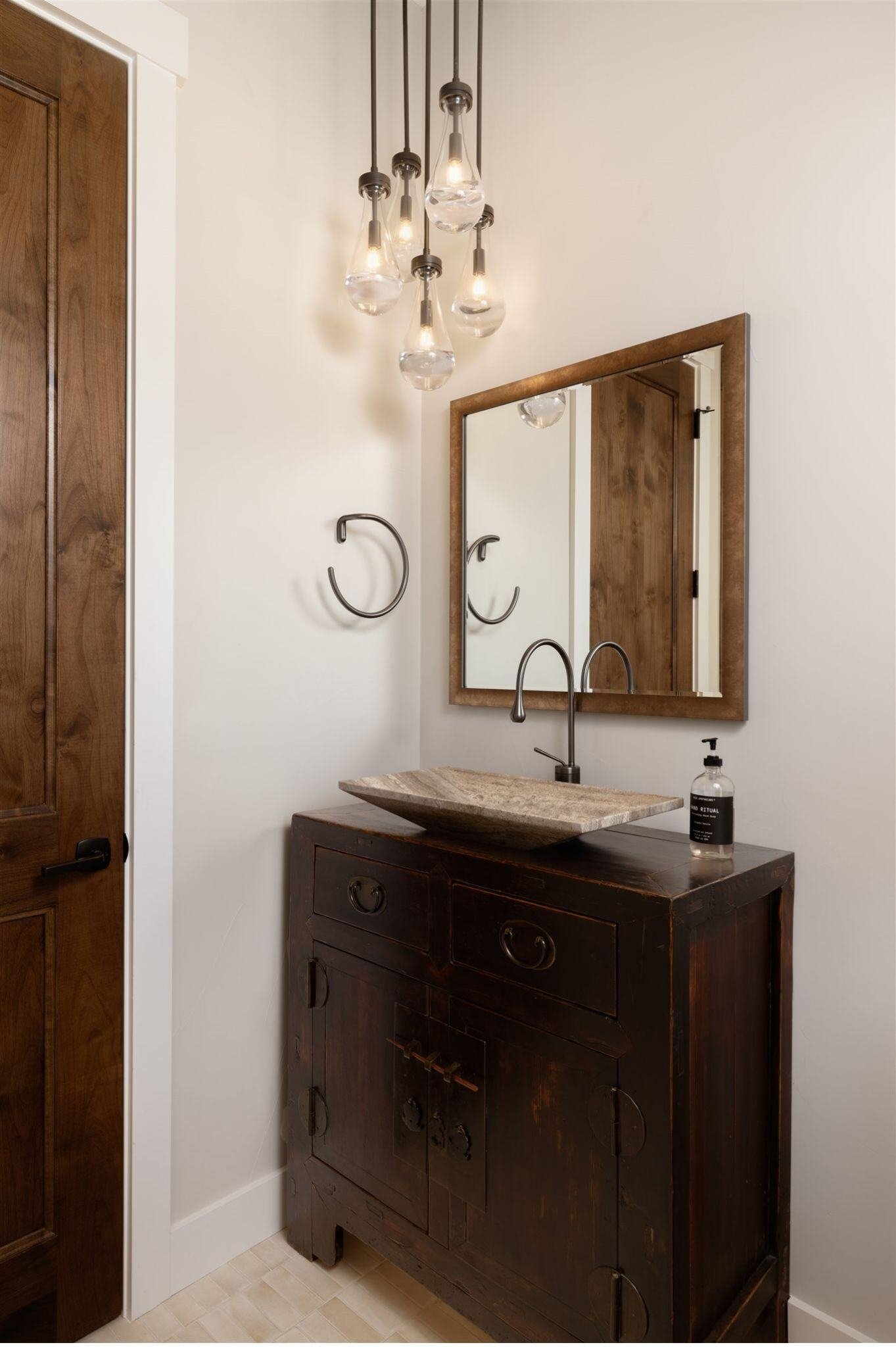 luxury half bathroom remodel with dark brown sink vanity and custom lighting