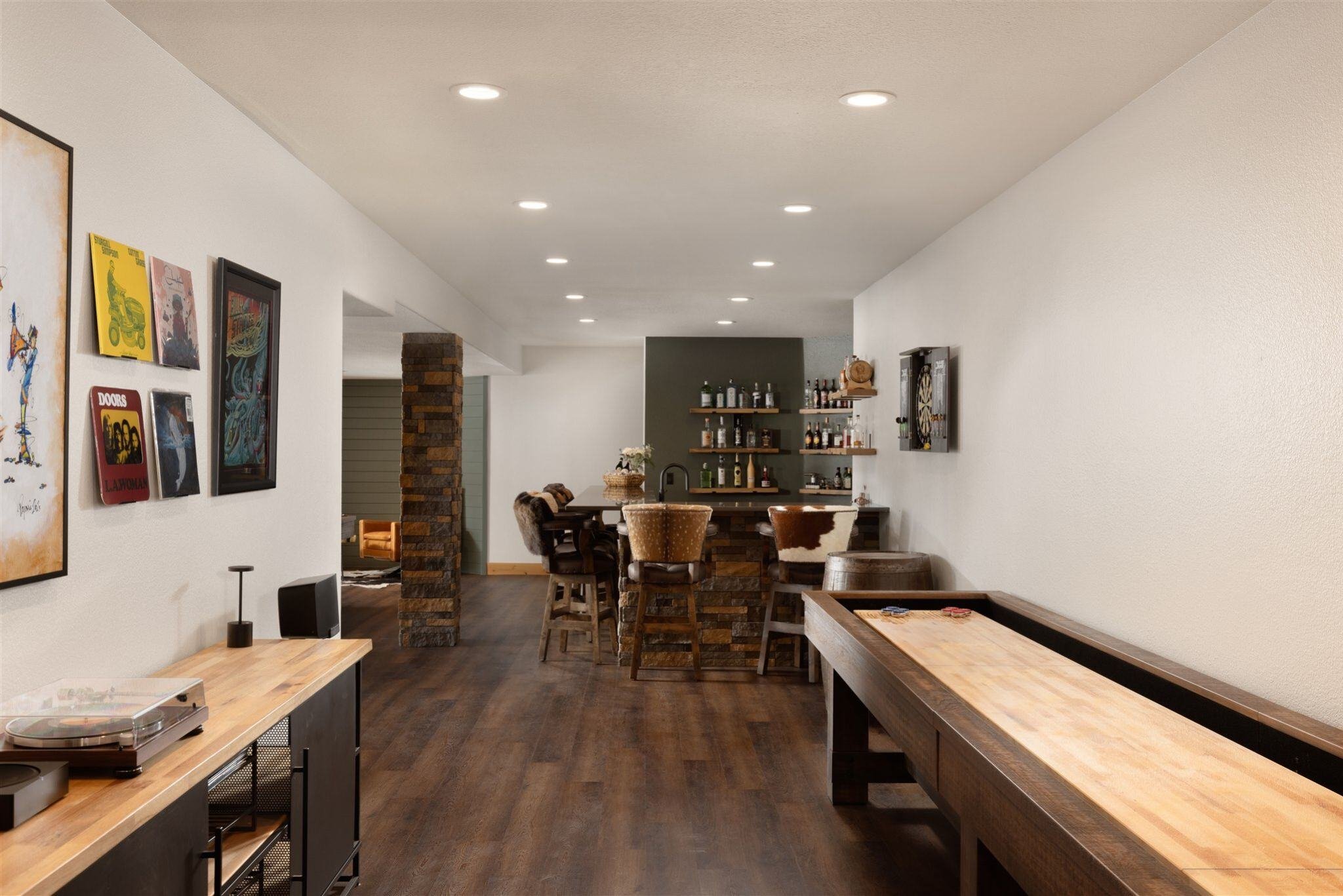 basement remodel with air hockey table, dining table, and dark floors