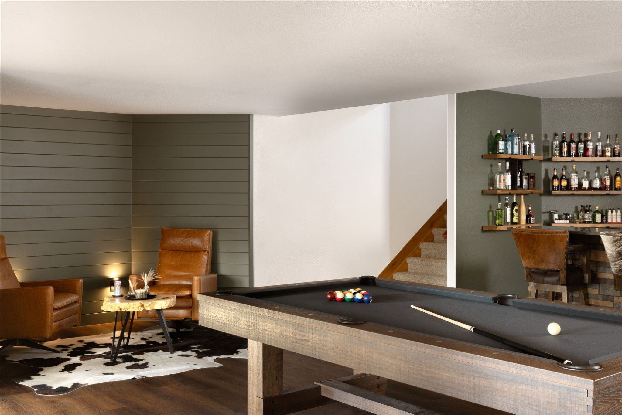 finished basement remodel with shiplap walls, cozy seating area, pool table, and bar
