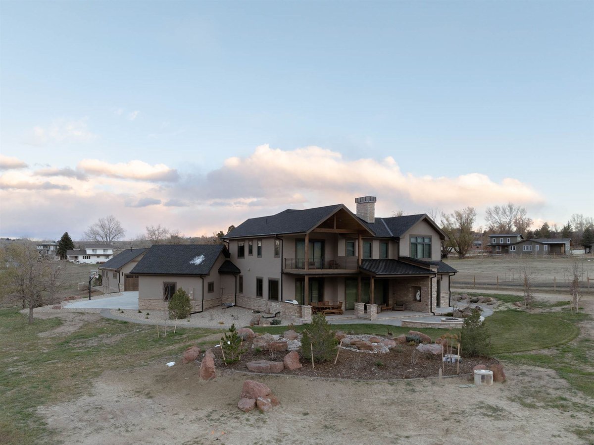 back of custom built home with double decker balconies and a large patio