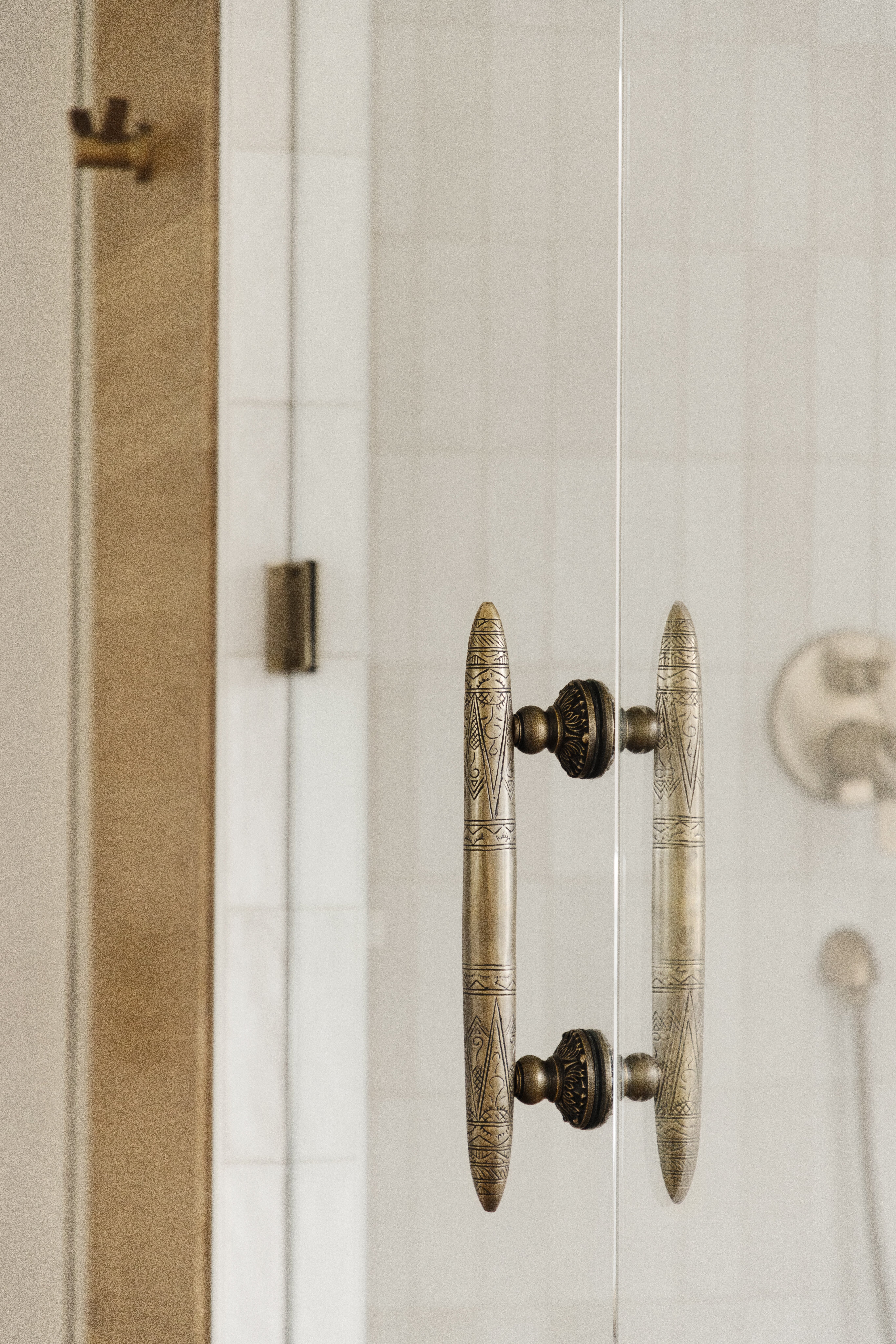 detailed door handle to shower door with a bronze finish