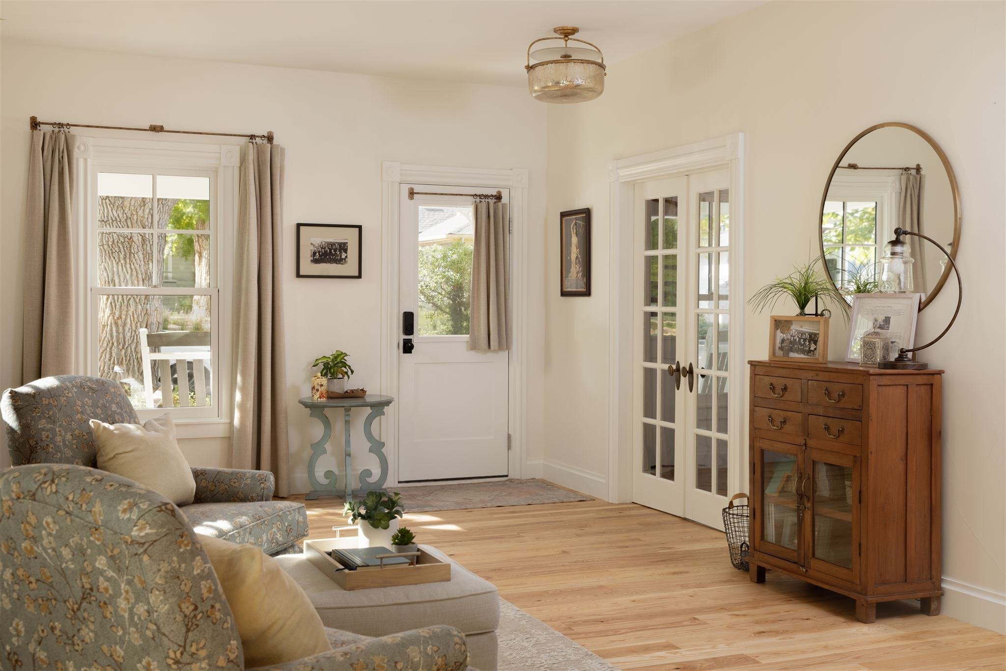 home entryway with light wood floors, tan curtains, and white walls