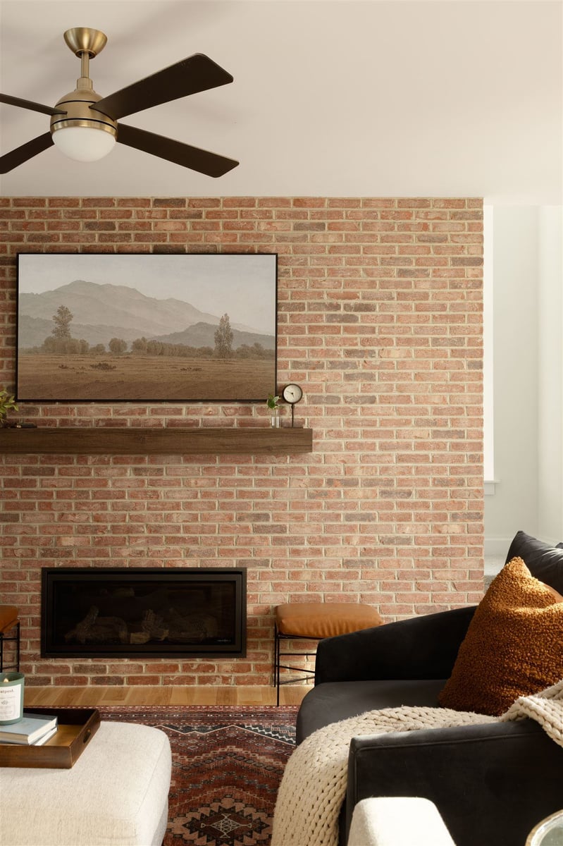 large brick fireplace and modern ceiling fan in a remodeled living room in Boulder Colorado
