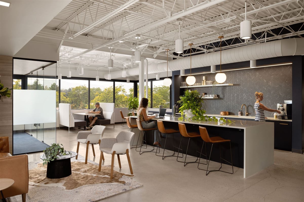 Coffee bar in a modern Colorado office with kitchen island seating, modern appliances, and a cozy seating area