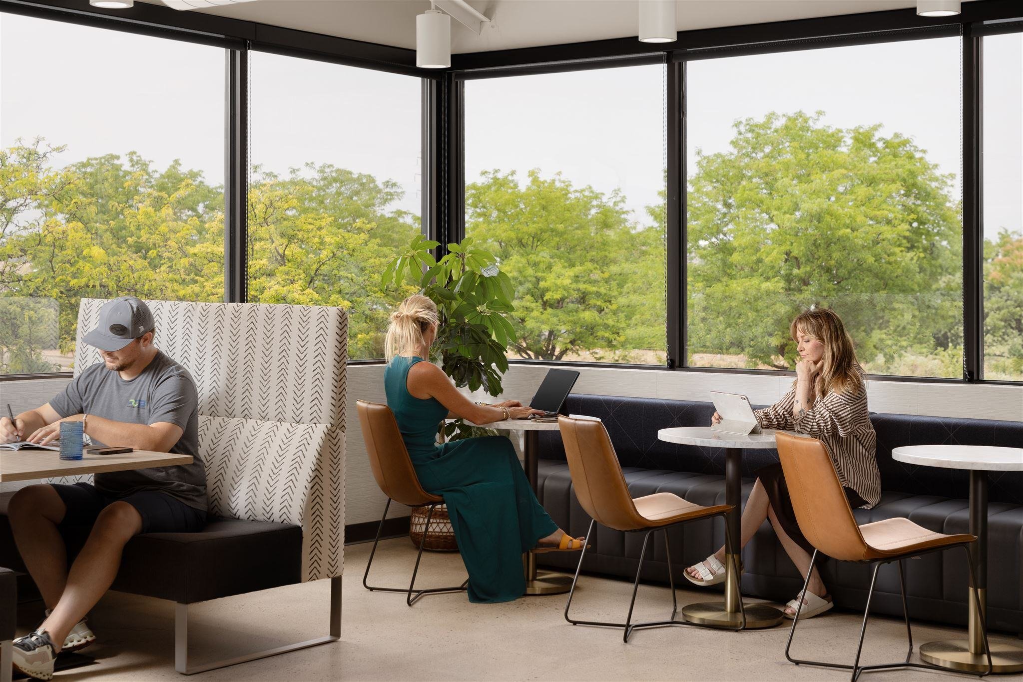 People working in a modern Colorado office with multiple seating options and large windows