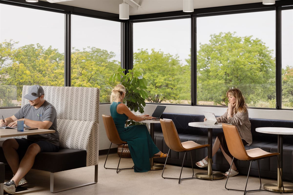 People working in a modern Colorado office with multiple seating options and large windows