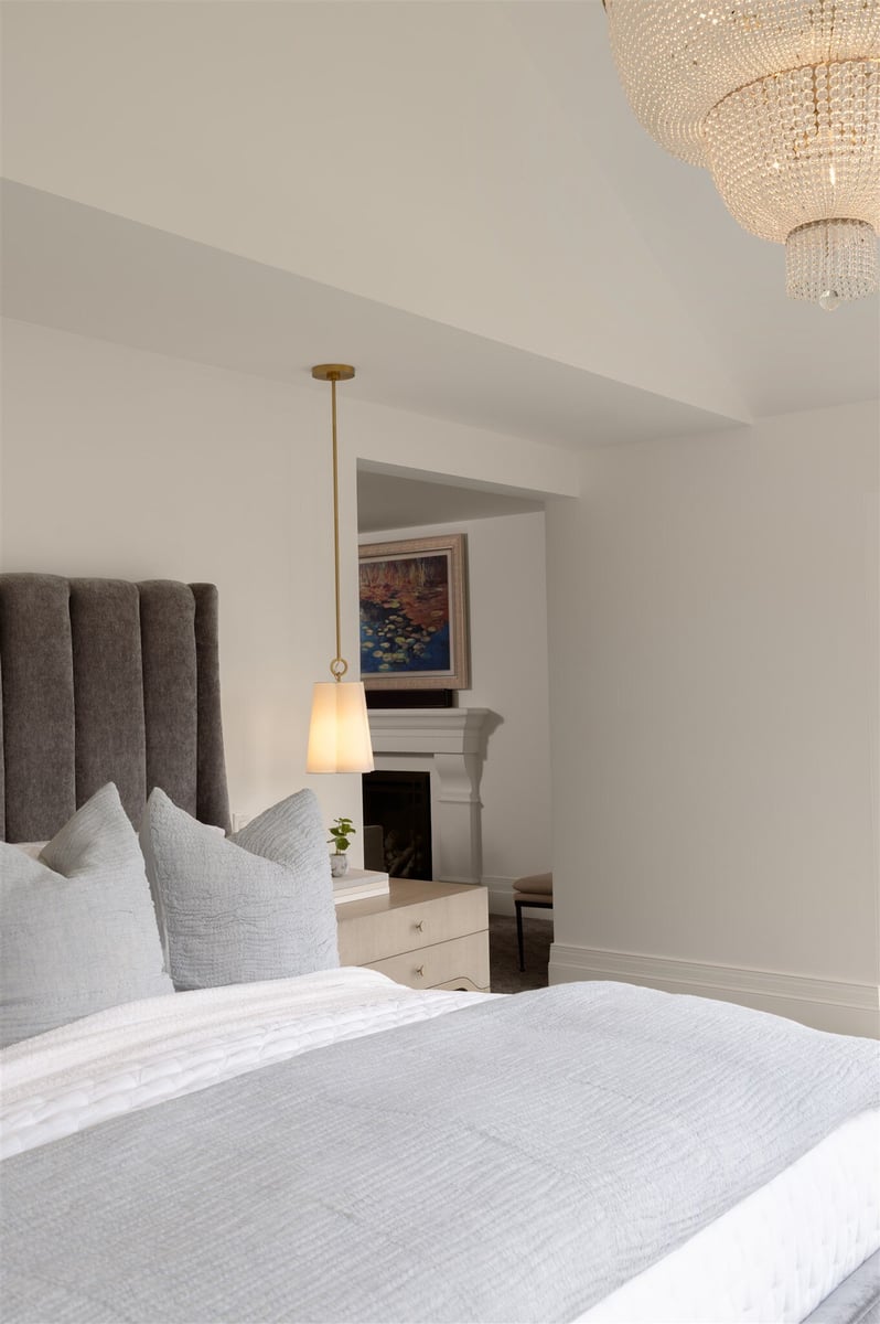 bedroom with custom lighting and a fireplace in a luxury colorado home