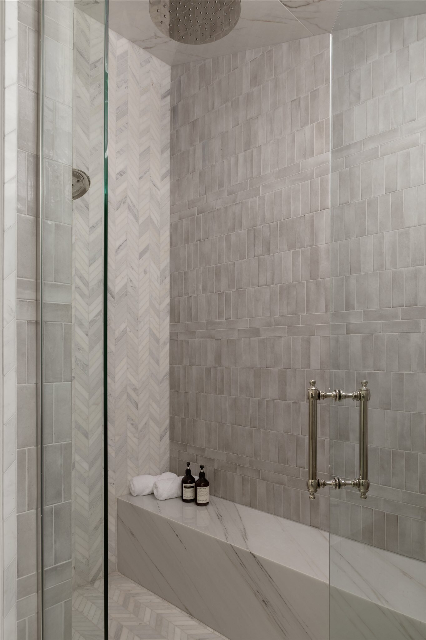 luxury shower with frameless glass door and marble bench