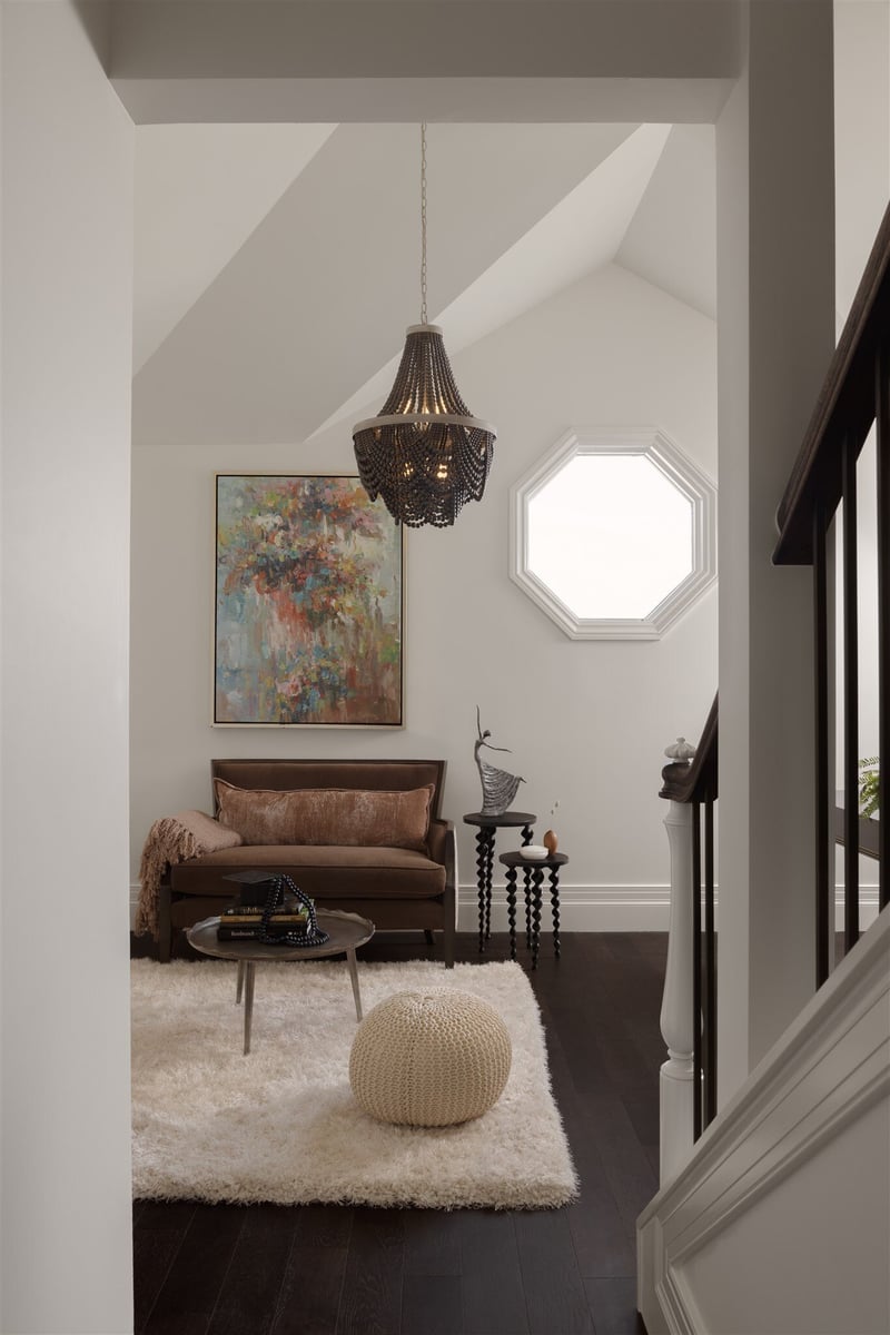 Home reading nook with black floors, white walls, and cozy furniture
