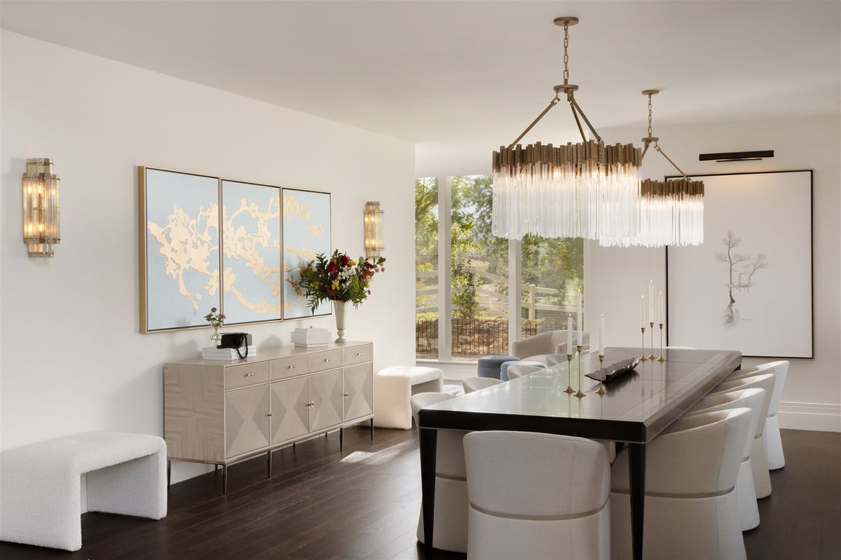 Remodeled luxury dining room with custom lighting fixtures and a large dining table